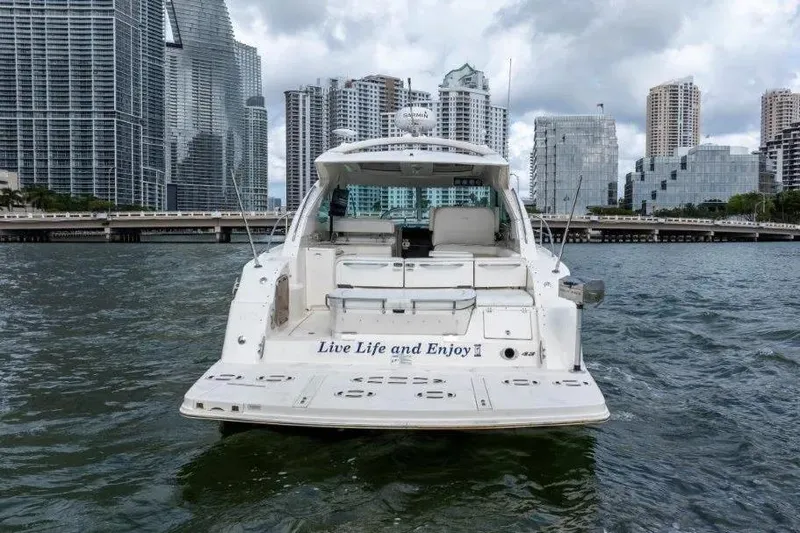 Slide: The Image of 2009 Sea Ray 43 Sundancer yacht on water with city skyline backdrop. - 10
