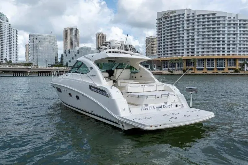 Slide: The Image of 2009 Sea Ray 43 Sundancer yacht on water, city skyline in background. - 13