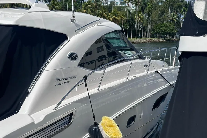 Slide: The Image of 2009 Sea Ray 43 Sundancer yacht docked by palm trees and water. - 14