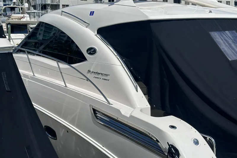 Slide: The Image of 2009 Sea Ray 43 Sundancer yacht docked, partially covered, showcasing sleek design. - 15