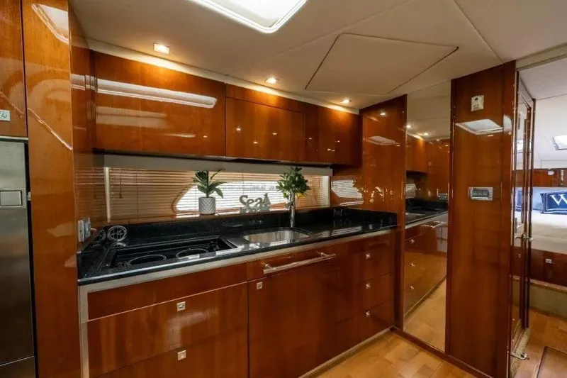 Slide: The Image of Luxurious 2009 Sea Ray 43 Sundancer yacht interior with sleek wooden cabinetry and modern kitchen amenities. - 19