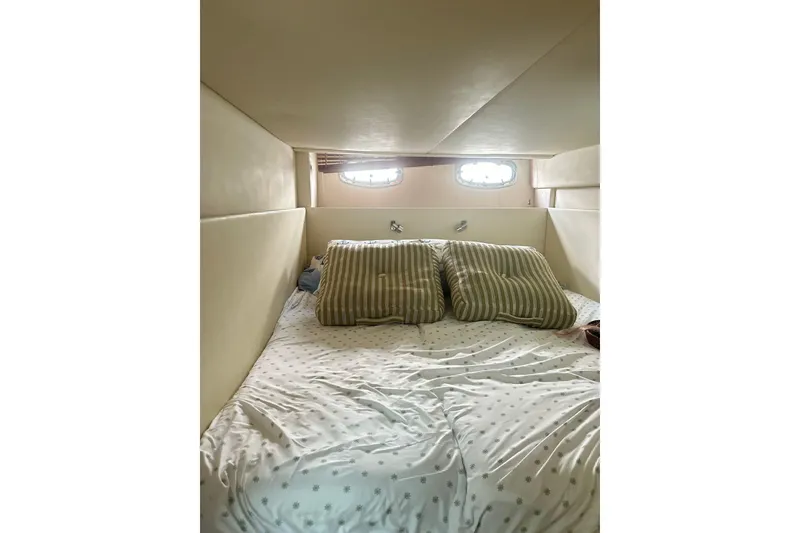 Slide: The Image of Cozy cabin interior of 2009 Sea Ray 43 Sundancer with striped pillows and porthole windows. - 29