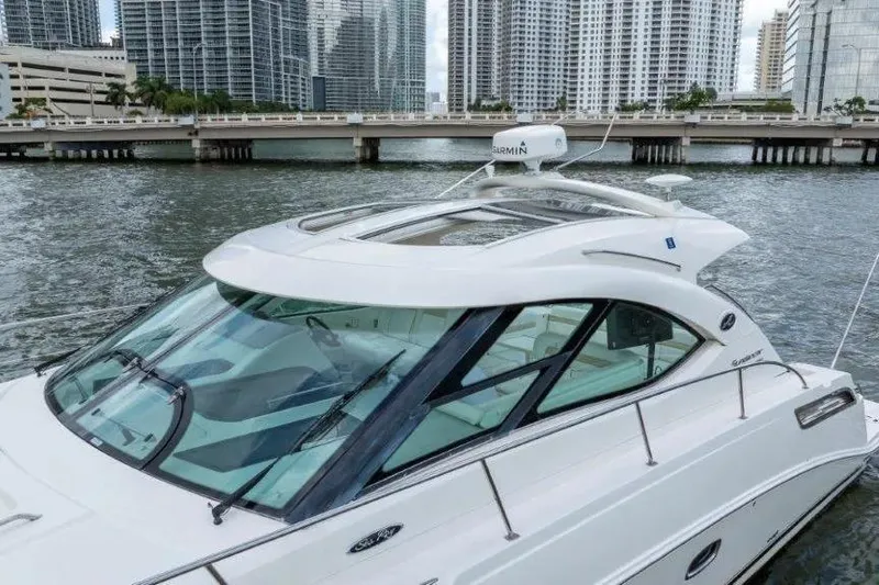 Slide: The Image of 2009 Sea Ray 43 Sundancer yacht docked near city skyline and bridge. - 4