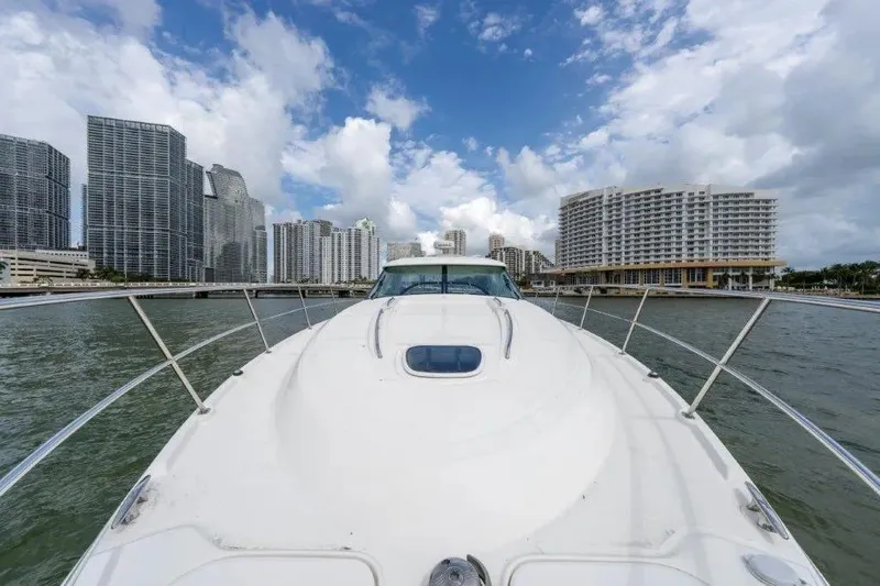 Slide: The Image of 2009 Sea Ray 43 Sundancer yacht cruising near city skyline under cloudy sky. - 54