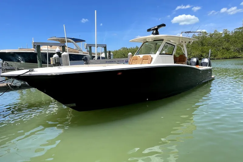 The Image of 2019 Scout 355 LXF boat on water under sunny skies. - 0