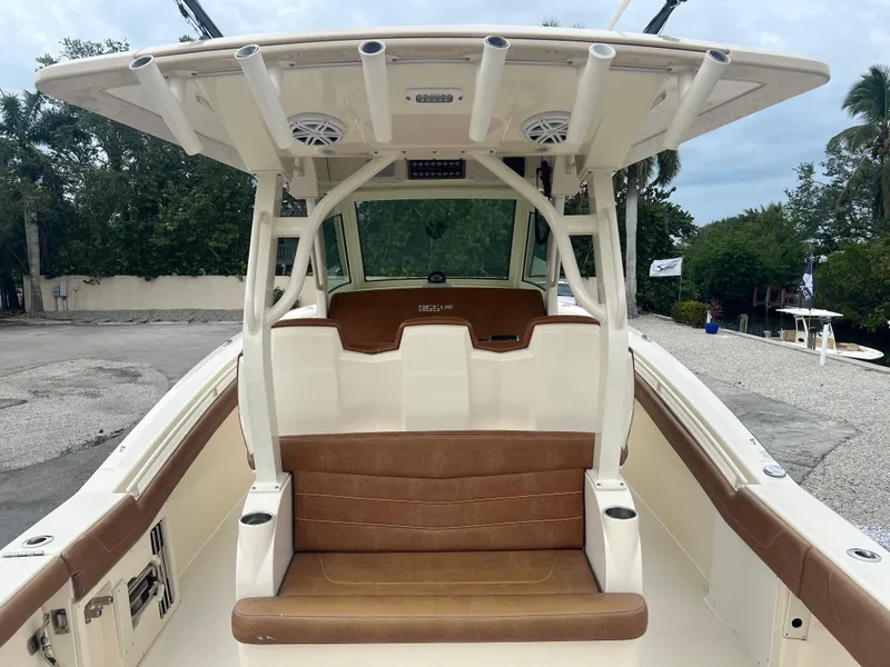 Slide: The Image of 2019 Scout 355 LXF boat with brown seating and white console, parked outdoors. - 11