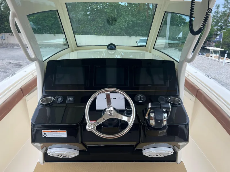 Slide: The Image of 2019 Scout 355 LXF boat dashboard with steering wheel and controls. - 12