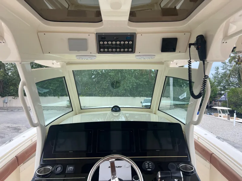 Slide: The Image of 2019 Scout 355 LXF boat helm with advanced navigation controls and steering wheel. - 13