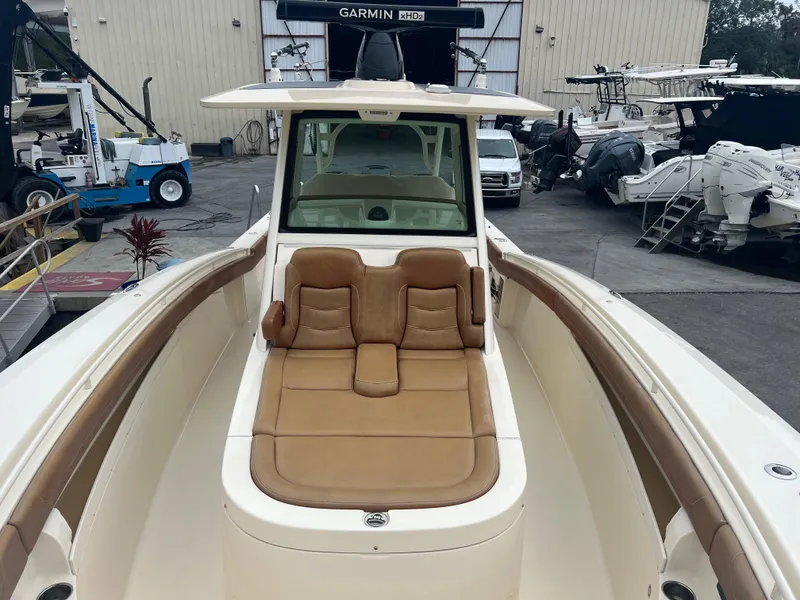 Slide: The Image of 2019 Scout 355 LXF boat with tan seating, docked at a marina. - 20