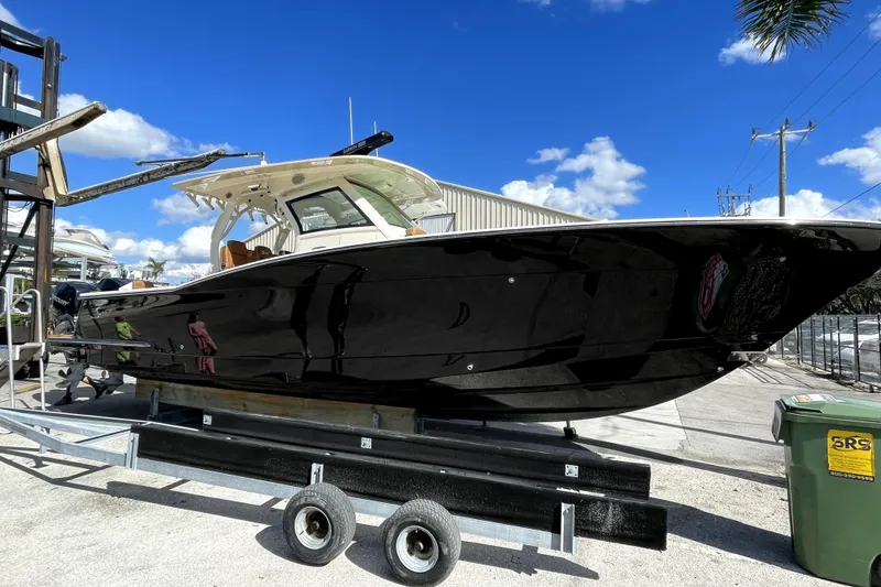 Slide: The Image of Scout 355 LXF 2019 boat on trailer under blue sky. - 25