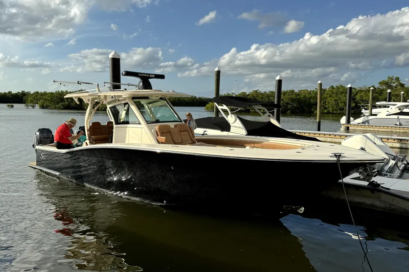 Slide: The Image of 2019 Scout 355 LXF boat docked on a sunny day. - 26