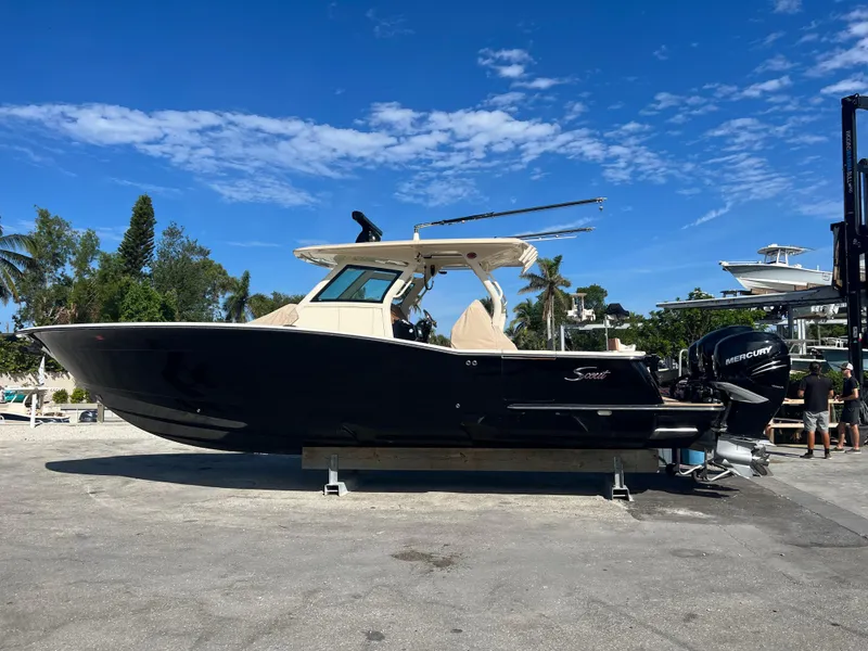 Slide: The Image of 2019 Scout 355 LXF boat on display under clear blue sky. - 3