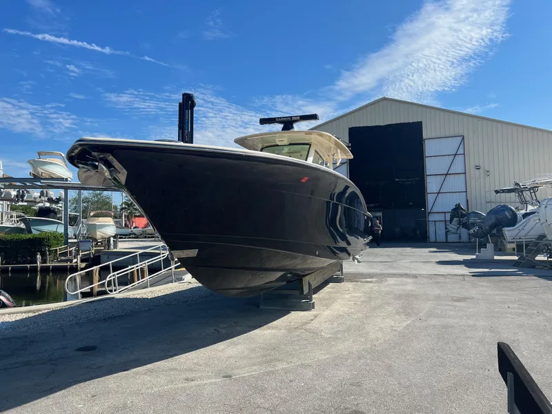 Slide: The Image of 2019 Scout 355 LXF boat on dry dock under clear blue sky. - 4