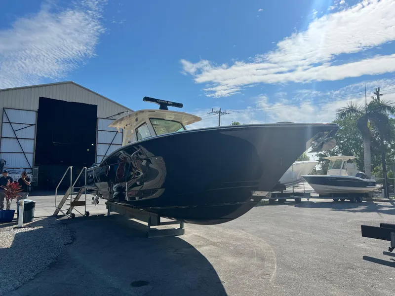 Slide: The Image of 2019 Scout 355 LXF boat displayed outdoors under a clear blue sky. - 5