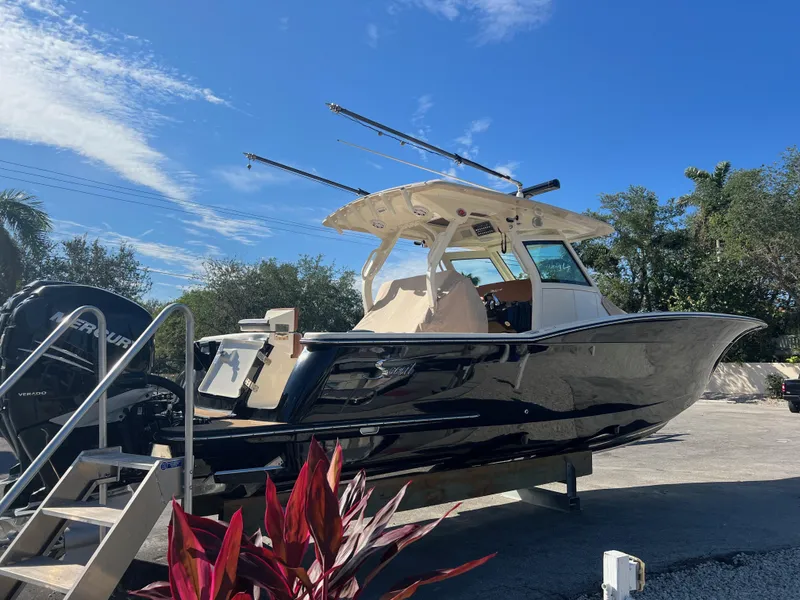 Slide: The Image of 2019 Scout 355 LXF boat on display under clear blue sky. - 7