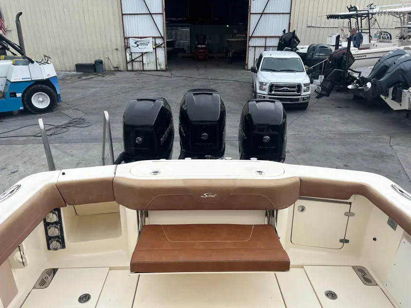 Slide: The Image of 2019 Scout 355 LXF boat with triple outboard engines in a marina. - 9