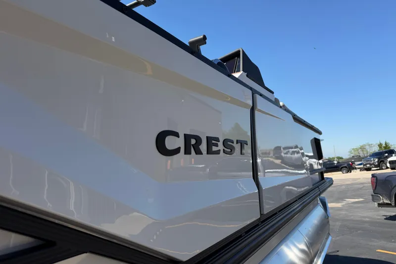 Slide: The Image of 2026 Crest Caribbean 250 SLS boat exterior with logo, under clear blue sky. - 13