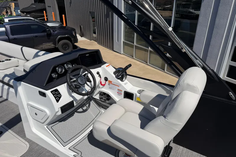 Slide: The Image of Interior view of 2026 Crest Caribbean 250 SLS boat with steering wheel and captain's chair. - 24
