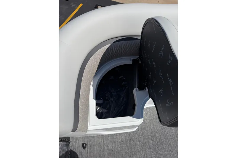 Slide: The Image of Open storage compartment in 2026 Crest Caribbean 250 SLS boat seat. - 25