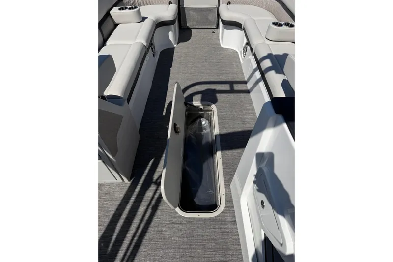 Slide: The Image of 2026 Crest Caribbean 250 SLS boat interior with open storage compartment and seating. - 29