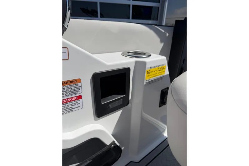 Slide: The Image of Interior of 2026 Crest Caribbean 250 SLS boat with warning labels and cup holder. - 30