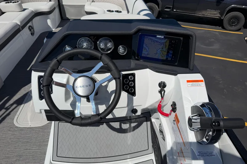 Slide: The Image of 2026 Crest Caribbean 250 SLS boat dashboard with steering wheel and navigation display. - 36