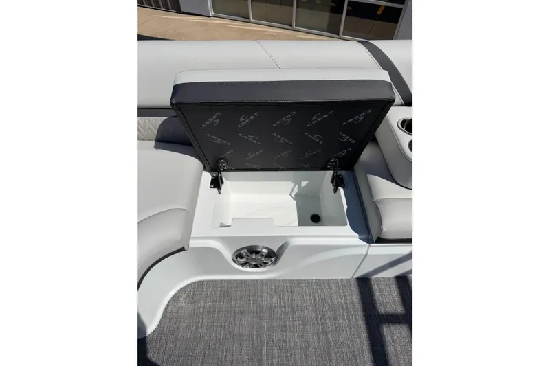 Slide: The Image of 2026 Crest Caribbean 250 SLS boat seat storage compartment with open lid and cup holders. - 37