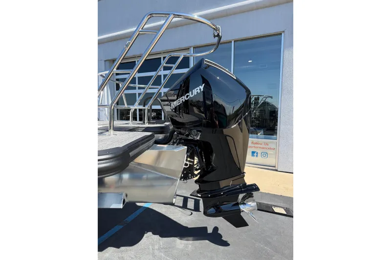 Slide: The Image of 2026 Crest Caribbean 250 SLS with Mercury outboard motor, docked near a building. - 6