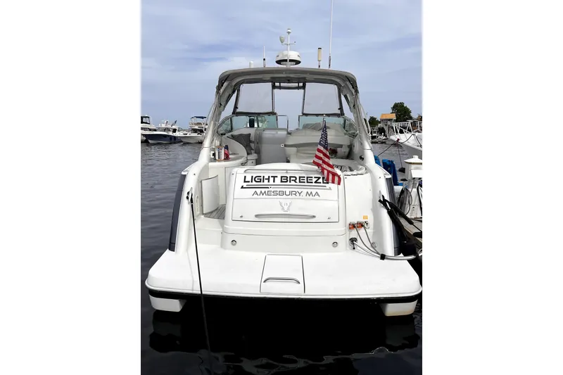 Slide: The Image of 2006 Formula 37 Performance Cruiser docked, rear view with American flag, "Light Breeze" name visible. - 3