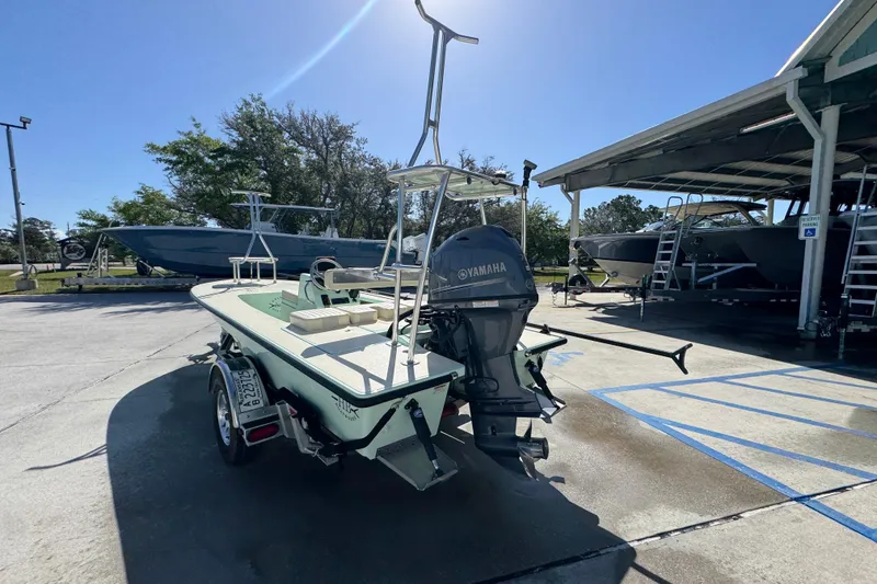 Slide: The Image of 2015 Hells Bay Professional boat with Yamaha motor in a sunny marina setting. - 13