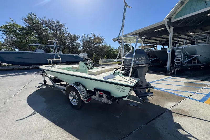 Slide: The Image of 2015 Hells Bay Professional boat on trailer, parked outdoors near other boats. - 14