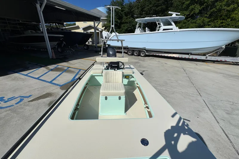 Slide: The Image of 2015 Hells Bay Professional boat in a marina, parked beside a larger vessel. - 19