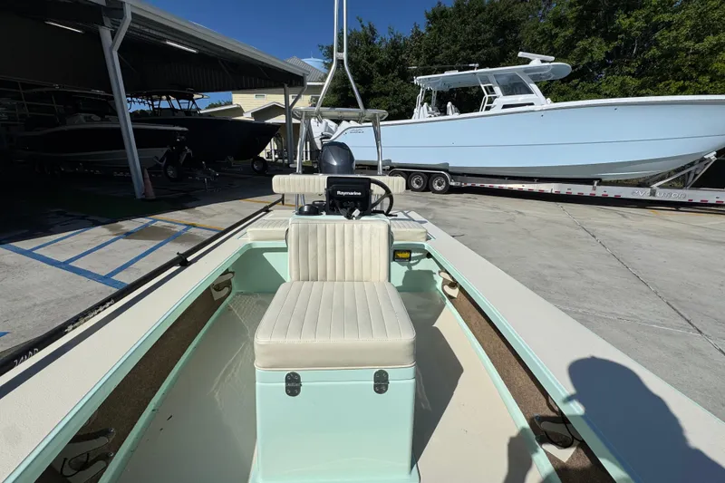 Slide: The Image of 2015 Hells Bay Professional boat in a marina, featuring a central console and seating. - 20