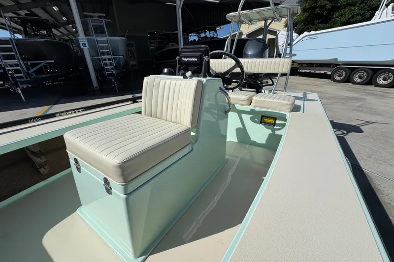 Slide: The Image of 2015 Hells Bay Professional boat with cushioned seating and steering console in a marina setting. - 21