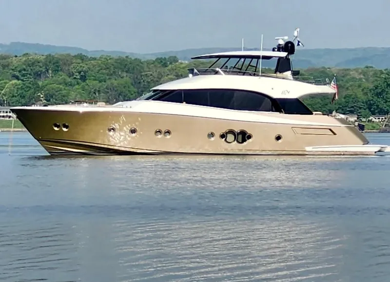 The Image of Luxurious 2012 Monte Carlo Yachts 76 cruising on a serene lake with lush green hills. - 0