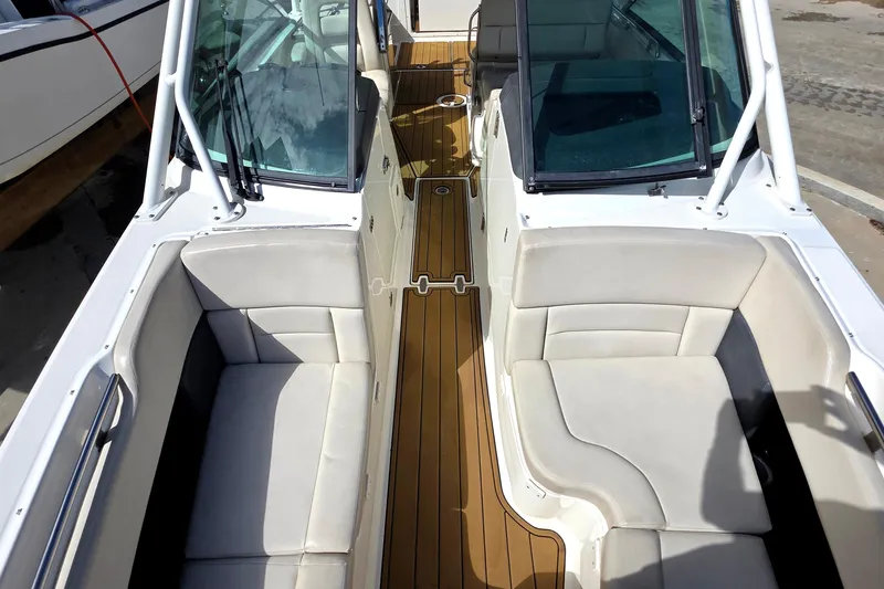 Slide: The Image of 2015 Boston Whaler 270 Vantage boat interior with cushioned seating and wooden flooring. - 10