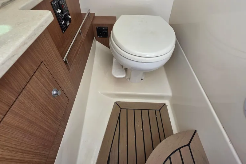 Slide: The Image of Interior of 2015 Boston Whaler 270 Vantage boat featuring a compact marine toilet. - 12