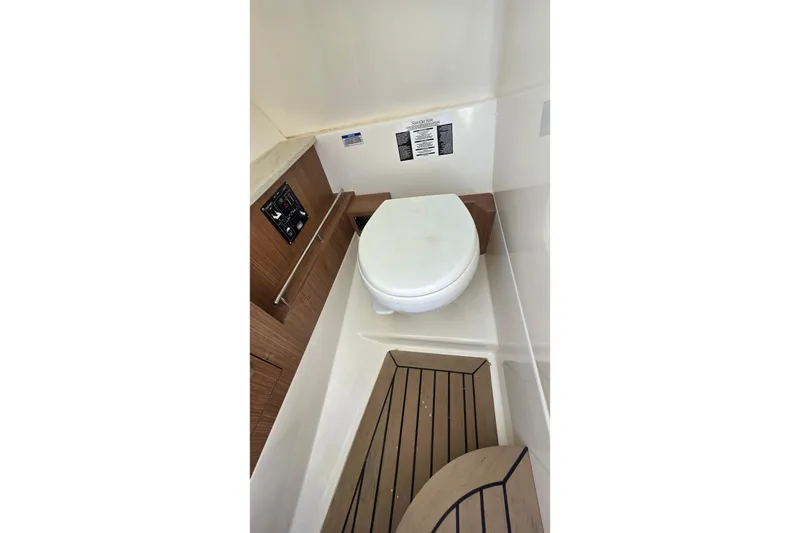 Slide: The Image of 2015 Boston Whaler 270 Vantage boat interior with toilet and wooden flooring. - 22