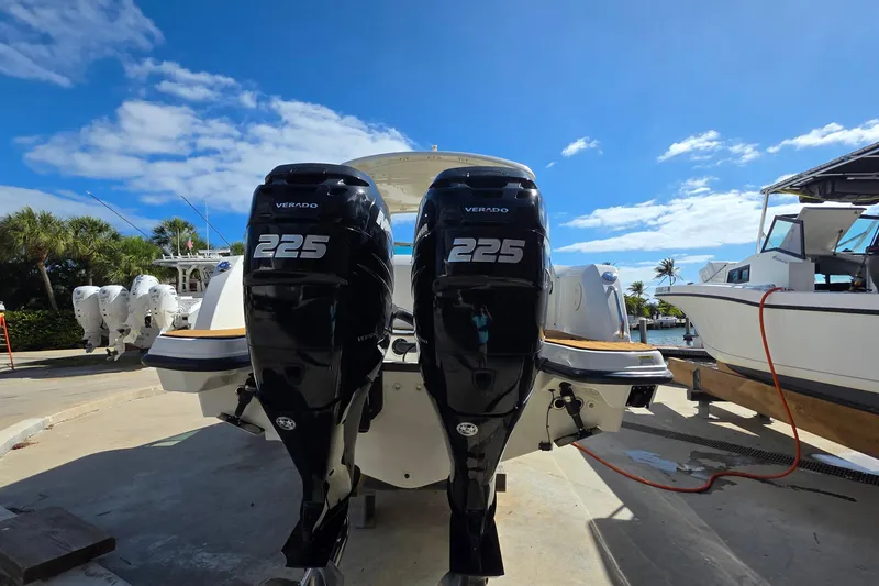 Slide: The Image of 2015 Boston Whaler 270 Vantage with twin Verado 225 engines, docked under a clear blue sky. - 23