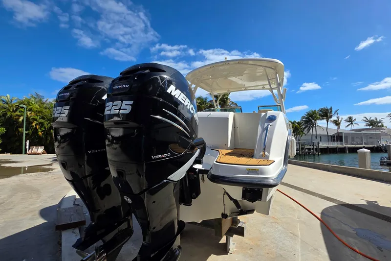 Slide: The Image of 2015 Boston Whaler 270 Vantage with twin Mercury 225 engines docked by the water. - 24