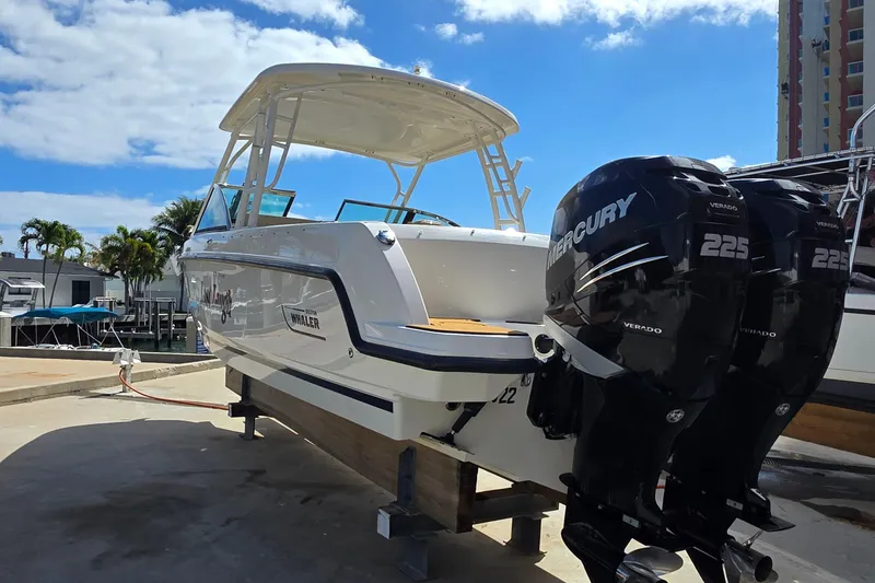 Slide: The Image of 2015 Boston Whaler 270 Vantage boat with twin Mercury 225 engines, docked under a clear sky. - 27