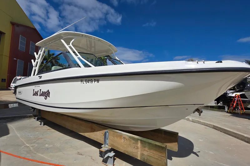 Slide: The Image of 2015 Boston Whaler 270 Vantage boat on display, named "Last Laugh," under a clear blue sky. - 3