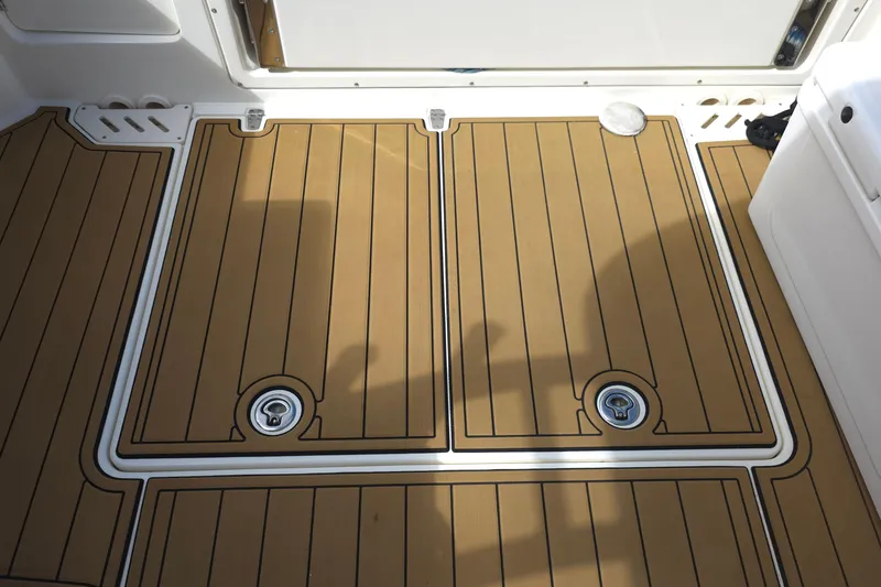 Slide: The Image of 2015 Boston Whaler 270 Vantage deck with teak-style flooring and storage compartments. - 39