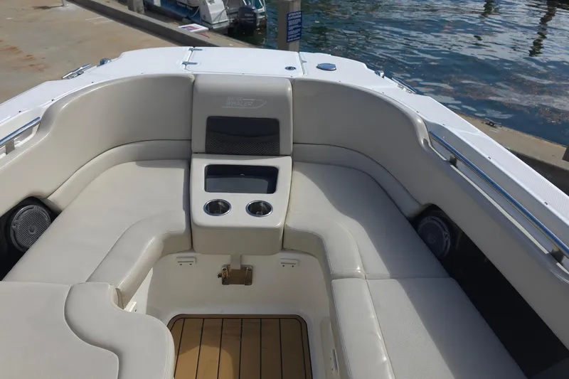 Slide: The Image of 2015 Boston Whaler 270 Vantage boat interior with cushioned seating and cup holders. - 53