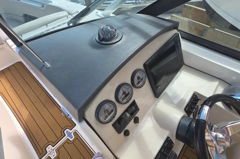 Slide: The Image of 2015 Boston Whaler 270 Vantage dashboard with gauges, compass, and steering wheel. - 56