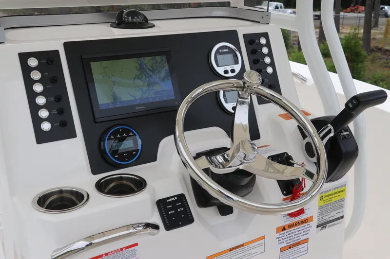 Slide: The Image of 2026 Robalo R200 Center Console dashboard with steering wheel, navigation screen, and controls. - 16