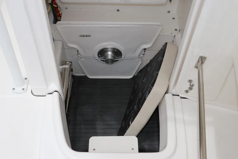 Slide: The Image of 2026 Robalo R200 Center Console storage compartment with cushioned seating and secure latch. - 23