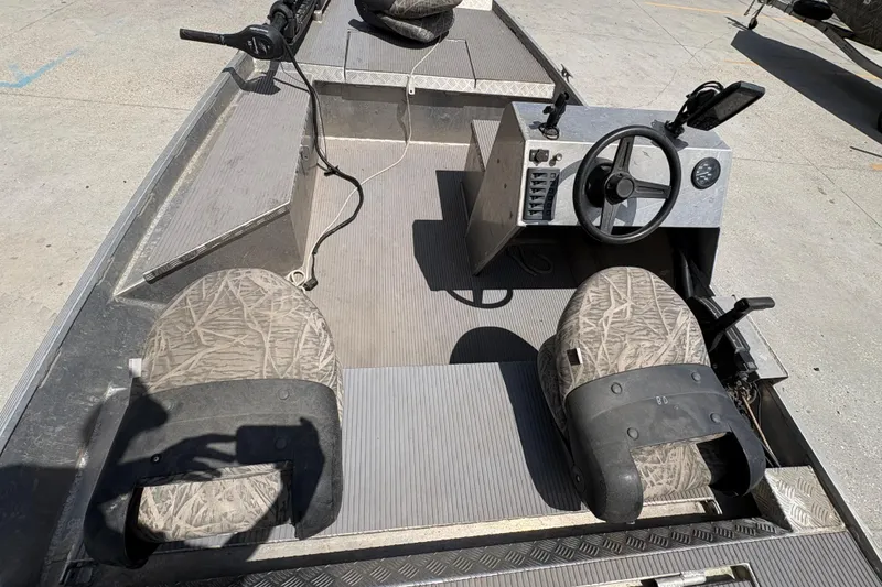 Slide: The Image of 2010 Custom Hanko 16' Side Console boat interior with steering wheel and patterned seats. - 14