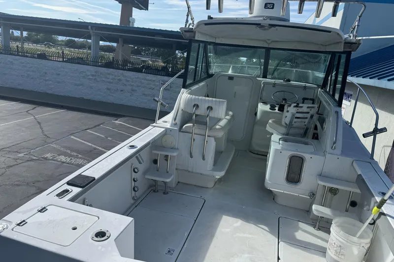 Slide: The Image of 2000 Glacier Bay 2680 Coastal Runner boat interior with seating and steering wheel. - 11