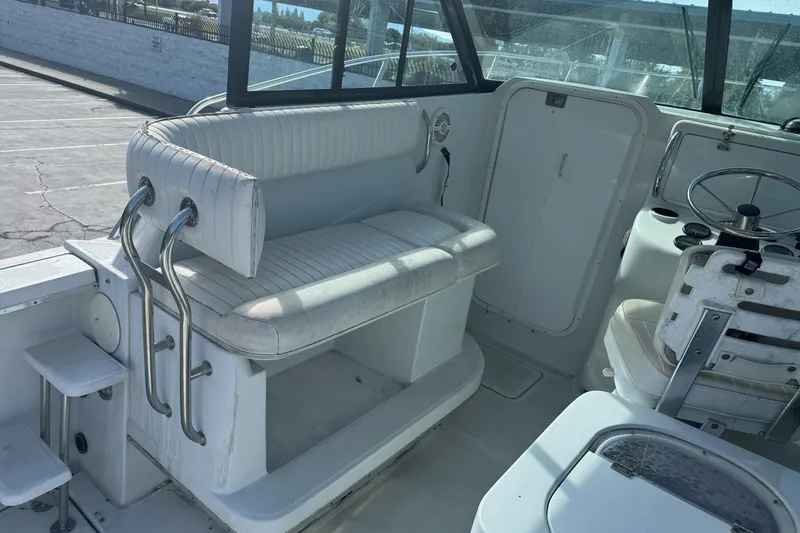 Slide: The Image of 2000 Glacier Bay 2680 Coastal Runner interior with white seating and steering wheel. - 14